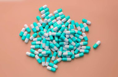 Pastel pembe üstten görünüm haplarla mavi kapsül yığını. Tıp Sağlık eczane Farmakoloji kavramı