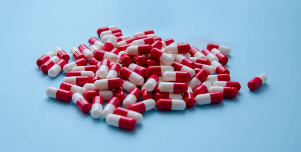 一堆红色胶囊的药丸在蓝色背景的顶部视图 医药卫生药学的药理学概念 — 图库照片