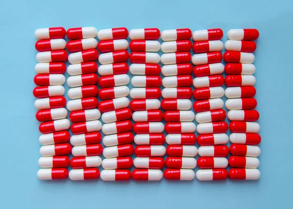Pílulas Cápsulas Vermelhas Brancas Encontra Uma Linha Fundo Azul Close — Fotografia de Stock
