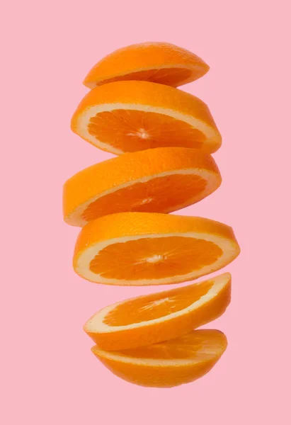 オレンジ色の飛行を持つ創造的なコンセプト ピンクの背景に分離されたオレンジのハエをスライスしました 空に浮かぶ軽さフルーツ — ストック写真