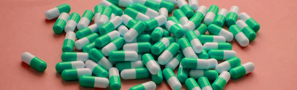 一堆绿色的药丸在粉红色的背景顶部的看法 医药卫生药学的药理学概念 — 图库照片