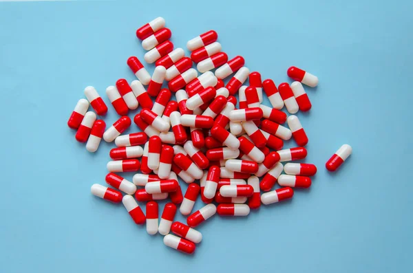 一堆红色胶囊的药丸在蓝色背景的顶部视图 医药卫生药学的药理学概念 — 图库照片