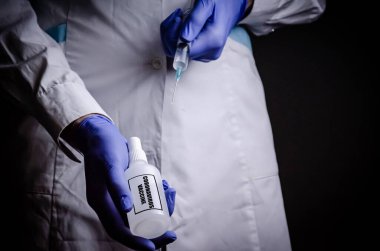 Coronavirus aşısı doktoru elinde, kovid-19 hastalığının adını kopyalamak için bir şırınga tutuyor. Tıbbi eldiven konsepti. Bilimsel çalışmalar bir hastalığın gelişimi ve tedavisi veya salgın hastalığın tedavisi.