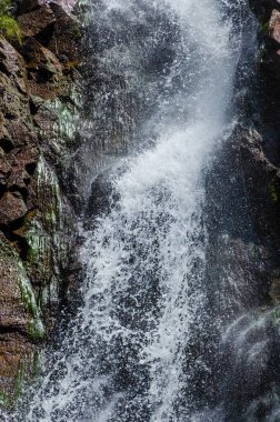 Dağlardaki kayalık bir vadide hızlı şelale.