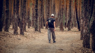 Ormanda kamuflajlı genç bir adam.