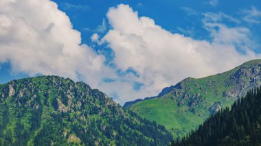 Bulutlu ve mavi gökyüzü olan dağ manzarası