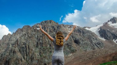 Dağın tepesinde duran kadın yürüyüşçü.
