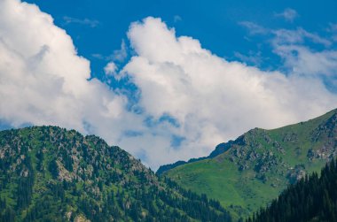 Bulutlu ve mavi gökyüzü olan dağ manzarası