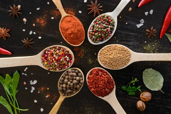 Tahta kaşıklar üzerinde çeşitli baharatlar. Gıda katkı maddeleri