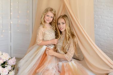 İki güzel kız bir stüdyoda. Onlar ışık güzel elbiseler giymek