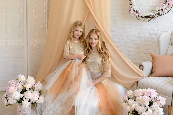 Dos chicas hermosas en un estudio. Llevan vestidos hermosos y ligeros — Foto de Stock