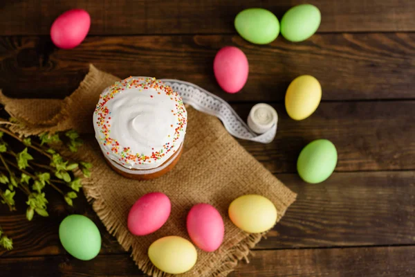 Easter cake and colorful eggs on a wooden table. It can be used as a background