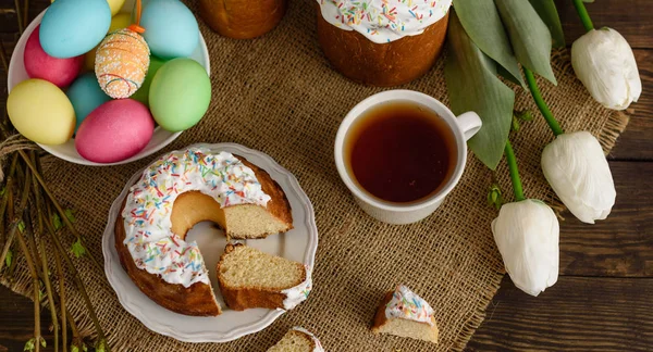 复活节蛋糕和五颜六色的鸡蛋在一张木桌上 它可以用作背景 — 图库照片