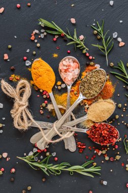 Tahta kaşıklar üzerinde çeşitli baharatlar. Gıda katkı maddeleri