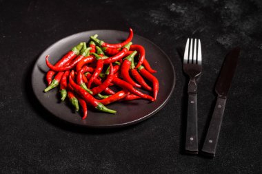 Gri beton arka planda parlak kırmızı biber. Baharatlı yemekler, malzemeler.