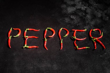 Gri beton arka planda parlak kırmızı biber. Baharatlı yemekler, malzemeler.