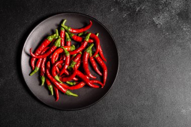 Gri beton arka planda parlak kırmızı biber. Baharatlı yemekler, malzemeler.