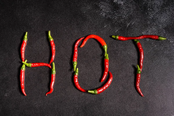 Leuchtend rote Chilischoten auf grauem Betongrund. würzige Speisen, Zutaten — Stockfoto