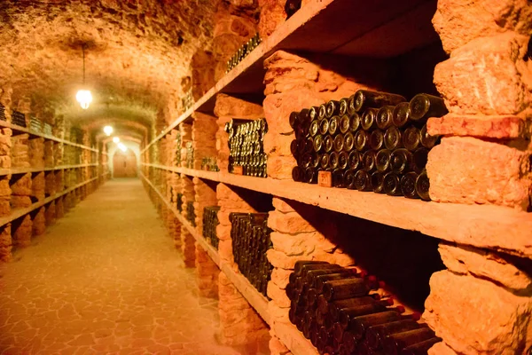 Красные бутылки вина в подвале — стоковое фото