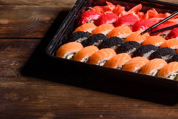 Różne rodzaje sushi serwowane na ciemnym tle — Zdjęcie stockowe