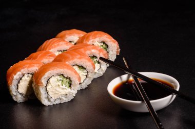 Karanlık bir arka planda servis edilen çeşitli suşi çeşitleri.