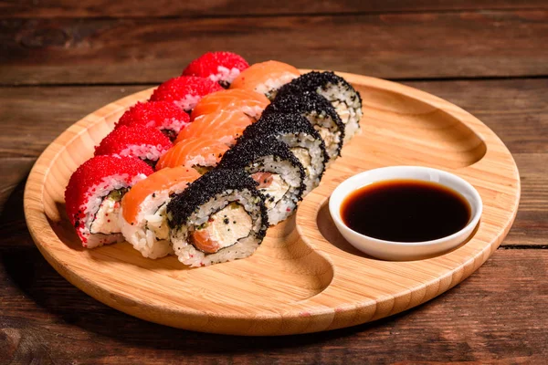 Różne rodzaje sushi serwowane na ciemnym tle — Zdjęcie stockowe