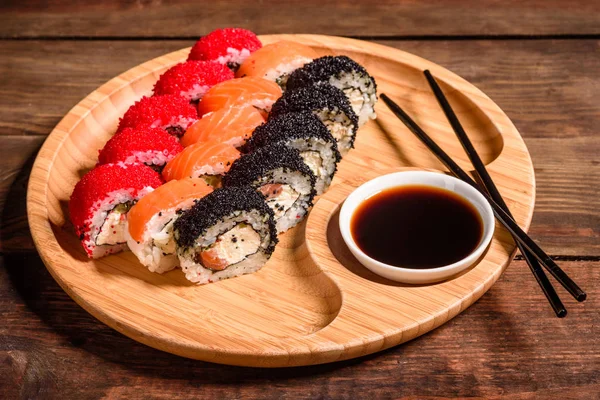 Różne rodzaje sushi serwowane na ciemnym tle — Zdjęcie stockowe