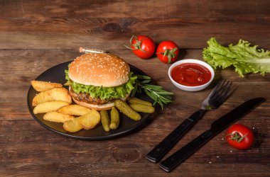Sığır eti, domates, peynir, salatalık, marul ile lezzetli ızgara ev yapımı hamburger