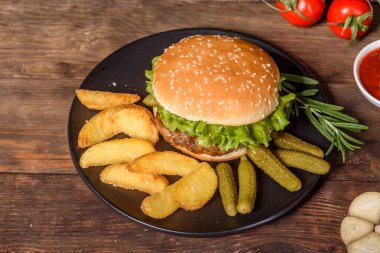 Sığır eti, domates, peynir, salatalık, marul ile lezzetli ızgara ev yapımı hamburger