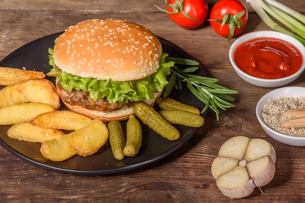 Tasty grilled homemade burger with beef, tomato, cheese, cucumber and lettuce — Stock Photo, Image