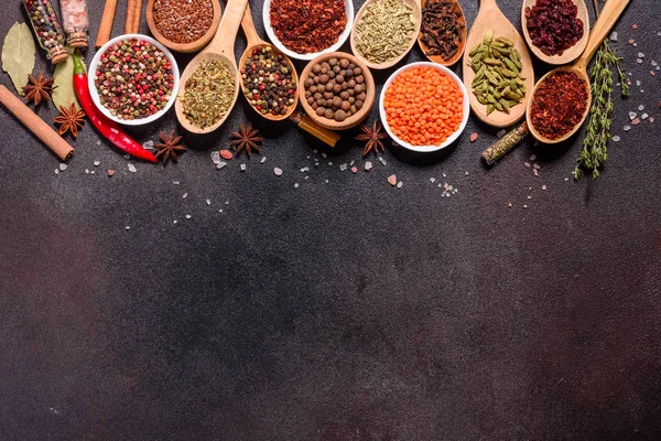 Um conjunto de especiarias e ervas. Cozinha indiana. Pimenta, sal, páprica, manjericão e outros em um fundo escuro — Fotografia de Stock