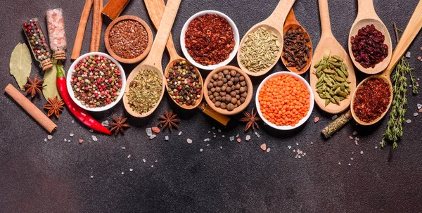 Una serie di spezie ed erbe. Cucina indiana. Pepe, sale, paprica, basilico e altro su fondo scuro — Foto Stock