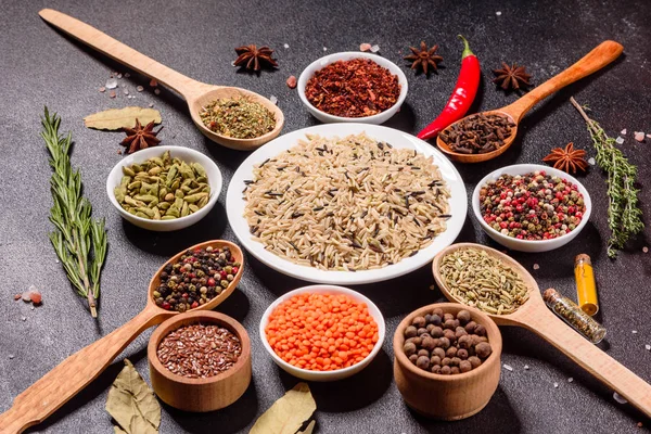 Een set kruiden en specerijen. Indiase keuken. Peper, zout, paprika, basilicum en andere op een donkere achtergrond — Stockfoto