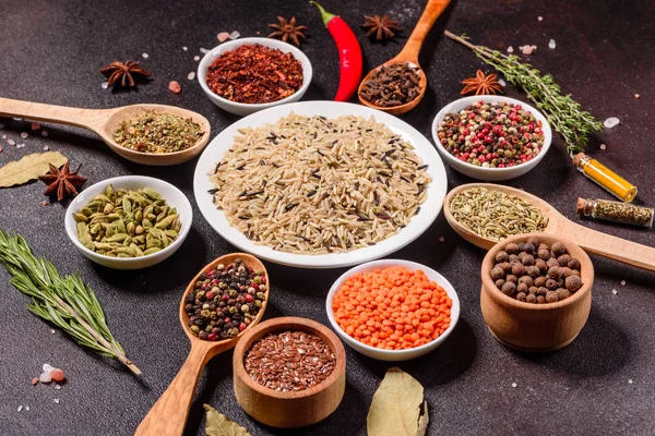 Een set kruiden en specerijen. Indiase keuken. Peper, zout, paprika, basilicum en andere op een donkere achtergrond — Stockfoto