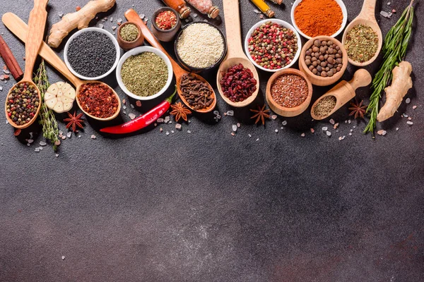 Spices and herbs over black stone background. Top view with free space for menu or recipes — Stock Photo, Image