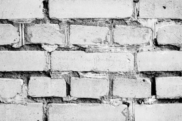 Texture d'un mur de briques avec des fissures et des rayures qui peuvent être utilisées comme fond — Photo