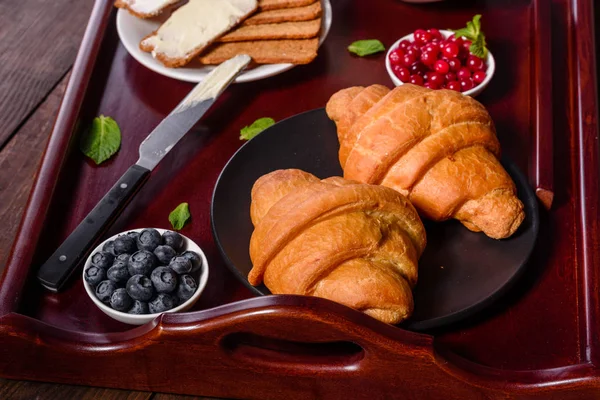 Delicioso café da manhã com croissants frescos e bagas maduras — Fotografia de Stock