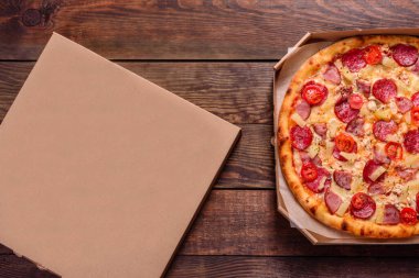 Beton zeminde deniz ürünleri ve domatesli dilimlenmiş pizza.