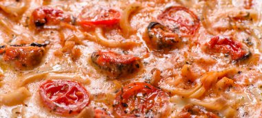 Beton zeminde deniz ürünleri ve domatesli dilimlenmiş pizza.