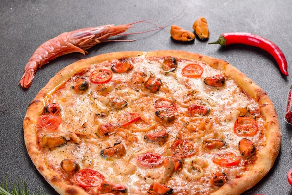 Вкусная нарезанная пицца с морепродуктами и помидорами на бетонном фоне — стоковое фото