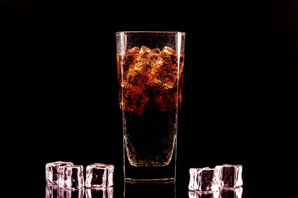 Bicchiere di cola con cubetti di ghiaccio e goccioline, isolato su fondo nero — Foto Stock