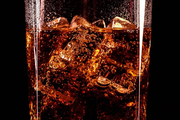 Ποτήρι Cola με παγάκια και σταγονίδια, απομονωμένο σε μαύρο φόντο — Φωτογραφία Αρχείου