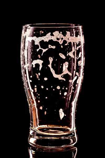 Copo de cerveja vazio usado com gotas em preto — Fotografia de Stock