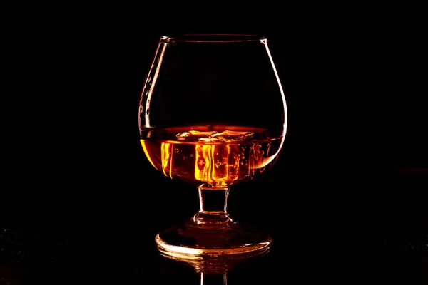 Whisky mit Eis im Glas isoliert auf schwarzem Hintergrund — Stockfoto