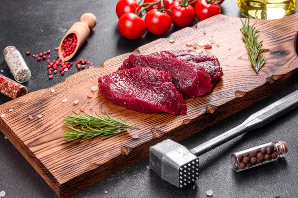 新鮮な生牛のステーキミニョン コショウ タイム トマト 新鮮な霜降り肉のステーキと調味料を暗い背景に — ストック写真