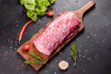 Mutfaktaki koyu bir arka planda pişmeye hazır taze domuz parçaları. Sığır filetosu madalyonları pişmeye hazır.