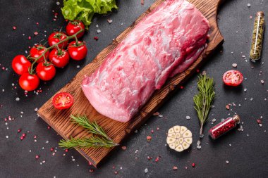 Mutfaktaki koyu bir arka planda pişmeye hazır taze domuz parçaları. Sığır filetosu madalyonları pişmeye hazır.