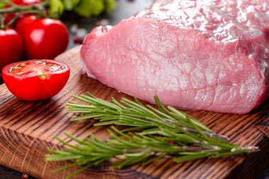 Mutfaktaki koyu bir arka planda pişmeye hazır taze domuz parçaları. Sığır filetosu madalyonları pişmeye hazır.