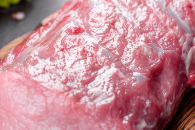 Mutfaktaki koyu bir arka planda pişmeye hazır taze domuz parçaları. Sığır filetosu madalyonları pişmeye hazır.