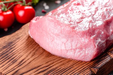 Mutfaktaki koyu bir arka planda pişmeye hazır taze domuz parçaları. Sığır filetosu madalyonları pişmeye hazır.